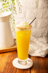 Pineapple cooler drink, served in a glass glass on a wooden table, in Mexico it is called Agua de Piña and is part of the traditional Aguas Frescas.