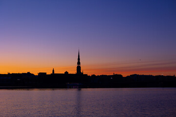 A beautiful Riga cityscape during colorful sunrise. Buildings against colorful sky. Northern Europe morning with warm sky.