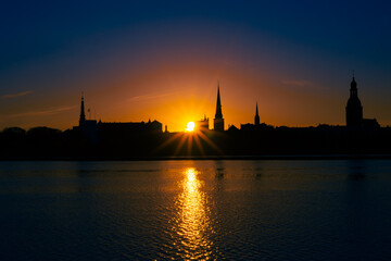Obraz premium A beautiful Riga cityscape during colorful sunrise. Buildings against colorful sky. Northern Europe morning with warm sky.