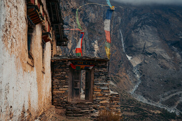 Door in an old monastery during Tsum Valley Trek, Nepal with waterfall