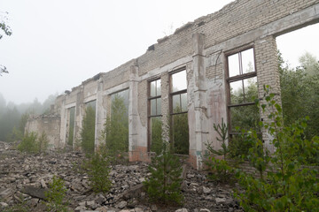 An old, collapsed building in soviet army base in Latvia, Europe. Abandoned white brick building.