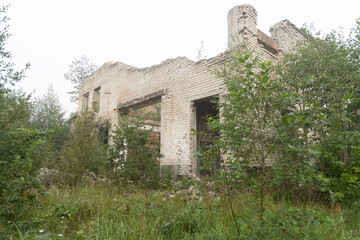 An old, collapsed building in soviet army base in Latvia, Europe. Abandoned white brick building.