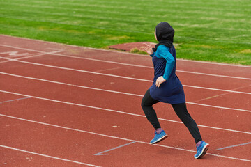 Fototapeta premium A muslim woman in a burqa sports muslim clothes running on a marathon course and preparing for upcoming competitions