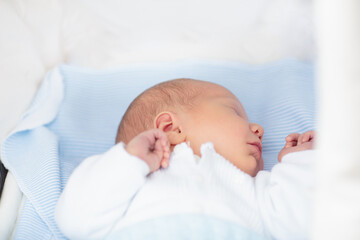 Sleeping newborn baby boy in a stroller