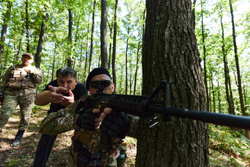 A disciplined and specialized military unit, donned in camouflage, strategically patrolling and...