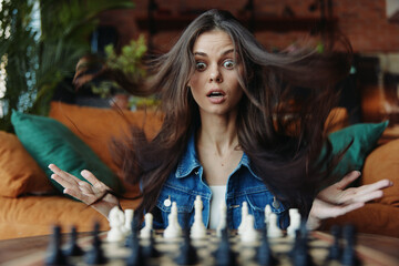 Young woman playing chess with hair blowing in wind, thoughtful strategy and unpredictable moves...