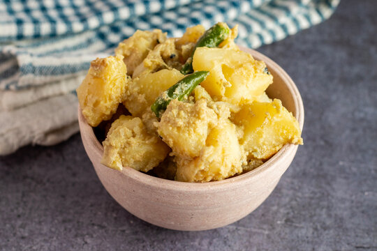 famous Bengali food "Aloo Posto" made with potato and poppy seeds serve on a white ceramic bowl. Selective focus. 
