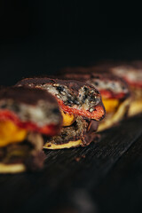 A still life of candies made of dehydrated fruits in dark chocolate at dark background