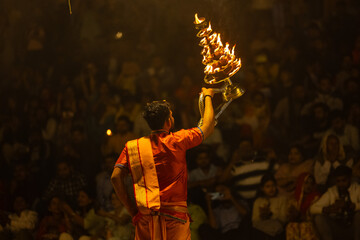 Ganga aarti, Portrait of young priest performing holy river ganges evening aarti at assi ghat in...