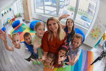 Children in a preschool institution standing in the classroom together with the teacher