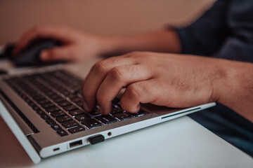 Close-up photo of a programmer typing on a laptop
