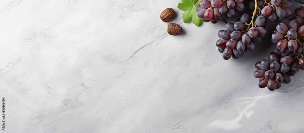 Wall mural A top view of wine and grapes on a grey marble background with ample copy space for additional elements or text