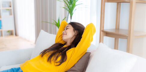 Happy Asian woman relaxing on the sofa at home - Smiling adorable girl enjoying day off lying on the couch, Healthy life style concept