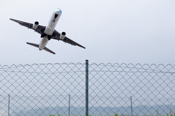 Passenger plane flying behind stainless steel fencing wire. Aviation idea concept. Deported....