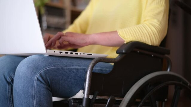 Anonymous Disabled Woman In Wheelchair Using Laptop To Work.