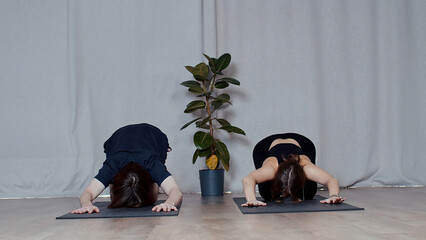 Young man and woman doing yoga on mats. Media. Concept of sport and body care.