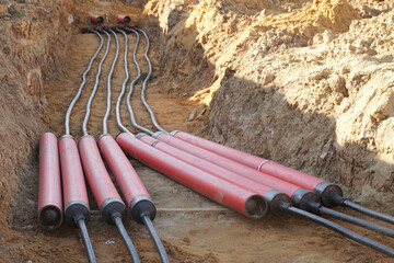 Laying polyethylene pipes for high-voltage cables underground.
