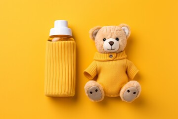 Adorable baby product banner  knitted toy and bottle on soft yellow background with space for text