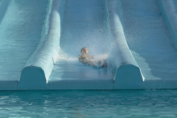 Person Sliding Down Water Slide in Pool - Fun Summer Activity for All Ages