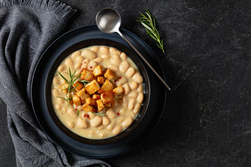 rosemary garlic creamy white bean soup in bowl - Powered by Adobe