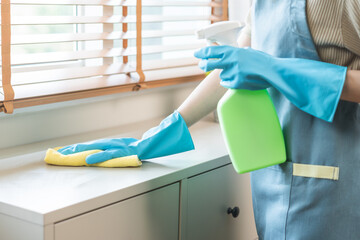 Cleanliness, asian young woman work chore cleaning on cupboard at home, hand wearing glove using...