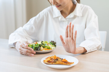 Diet concept, asian young woman close up hand push out away Pizza, refuse junk process, carb food...