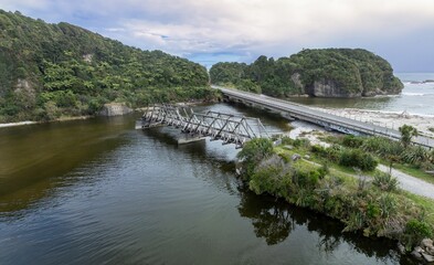 Fototapeta premium Road bridges and the The Fox River flowing into the ocean, West Coast, New Zealand.