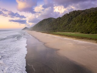 Farmland and tropical beach leading to the heaphy track. Karamea, Karamea, West Coast, New Zealand.