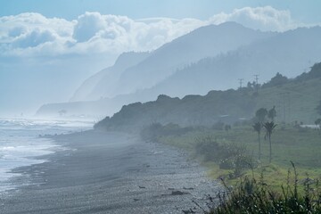 Ocean coastline and mountains near Karamea, West Coast, New Zealand.