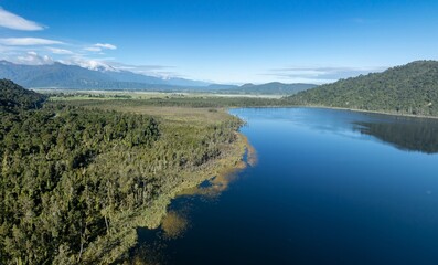 The calm mirror Lake Lanthe and forest, Harihari, West Coast, New Zealand.