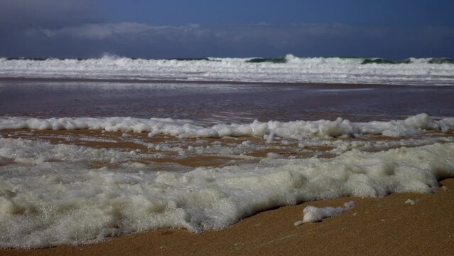 Foam caused by waves on the wild beach. Super Slow motion 4K