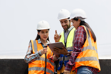 Engineers working on railway train statation and holding laptop for plan and meeting. Portrait of professional leadership of engineering teamwork. Warehouse and successful concept.