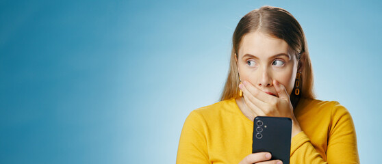 Woman, shocked and reading with smartphone in studio, blog update and message notification on...