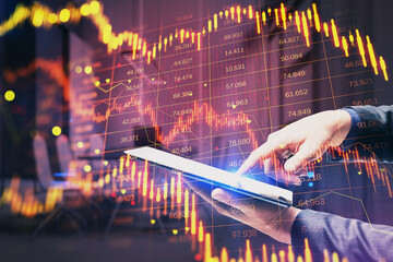 Close up of male hand pointing at cellphone with downward red forex candlestick hologram on blurry office interior background. Financial crisis, stock and recession concept. Double exposure.