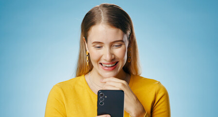 Woman, happy and reading with smartphone in studio, blog update and message notification on...