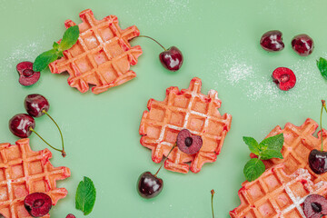 Homemade Belgian Waffles with sweet cherries. Gluten-free red dessert, fresh fruits and basil