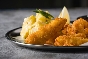 Deep fried shrimp tempura with potato salad on a metal plate