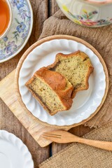 Banana cake with hot tea , set afternoon tea on wooden blackground, top view food table