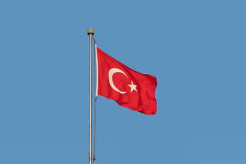 The flag of Republic of Turkiye with a white crescent and a star on red background