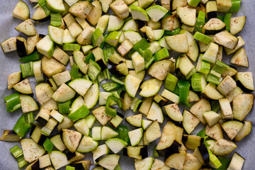 Eggplant, zucchini and peppers cut into diced and placed on a baking tray