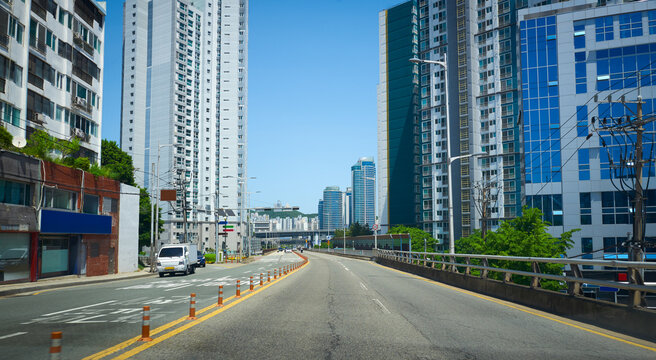 Urban roadway with skyscrapers under blue sky
