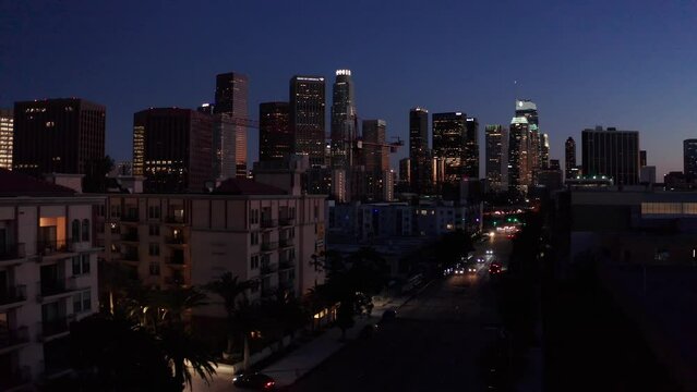 Aerial low push-in shot of the busy 110 Freeway in downtown Los Angeles as night descends in Southern California. 4K