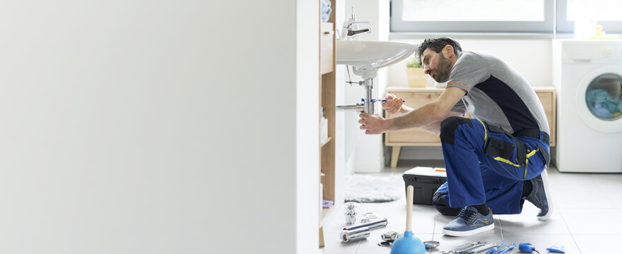 Professional plumber fixing a bathroom sink