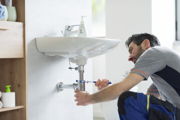 Professional plumber fixing a bathroom sink