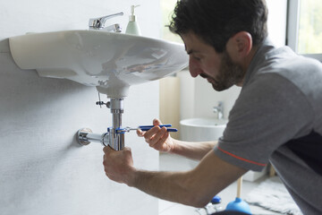 Professional plumber fixing a sink