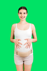 Portrait of supporting bandage on pregnant woman at green background with copy space. Orthopedic...