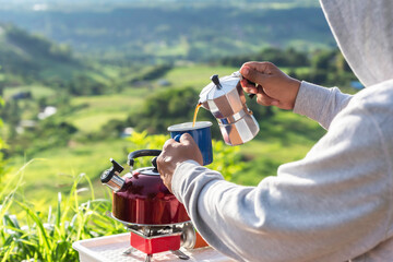 Making drip coffee with a beautiful mountain and nature view in background