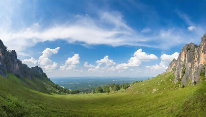 Obraz premium Beautiful panoramic view of mountain and meadow with blue sky