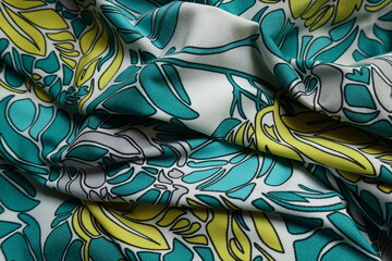 Folded blue green, white, yellow and grey polyester fabric