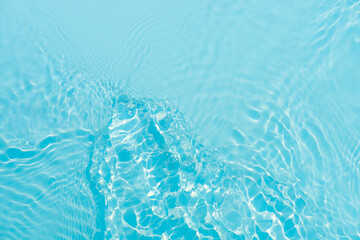 Blue water with ripples on the surface. Defocus blurred transparent blue colored clear calm water surface texture with splashes and bubbles. Water waves with shining pattern texture background.